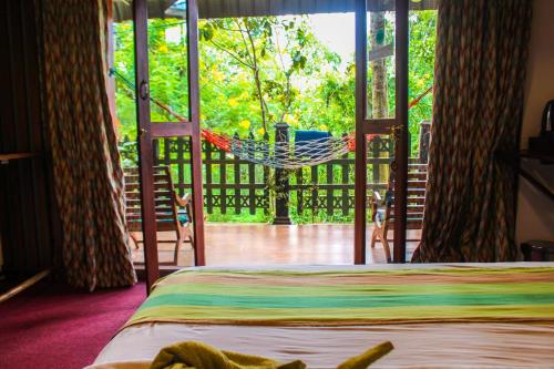 een hangmat in een kamer met een hangmat op een veranda bij Ella Mc Queen Homestay in Ella