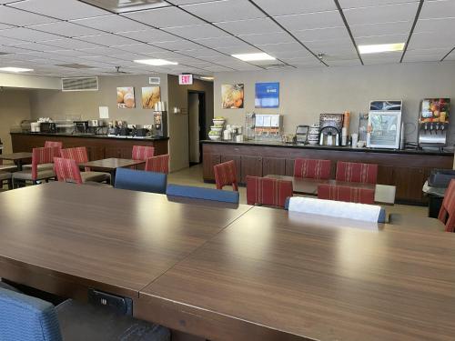 une cafétéria avec une grande table et des chaises en bois dans l'établissement Comfort Inn Falls Church - Tysons Corner, à Falls Church