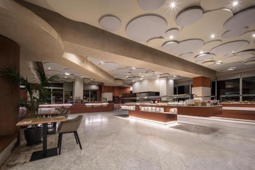 un vestíbulo con un restaurante con mesa y sillas en Eurostars Al-Ándalus Palace, en Sevilla