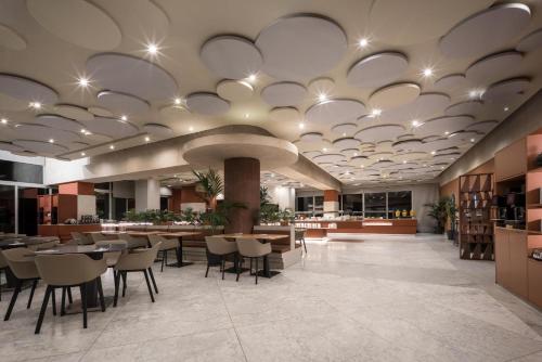 un vestíbulo con una cafetería con mesas y sillas en Eurostars Al-Ándalus Palace, en Sevilla