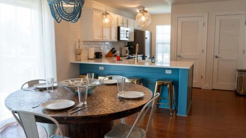 une cuisine avec une table, des chaises et un îlot bleu dans l'établissement Modern Beach Home with Pool Steps Away, à South Padre Island