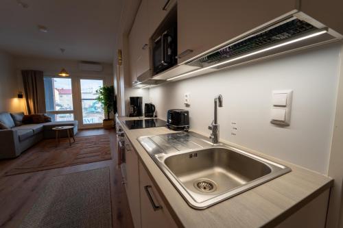 a kitchen with a sink and a living room at Snowflake XII Family rooms in Rovaniemi