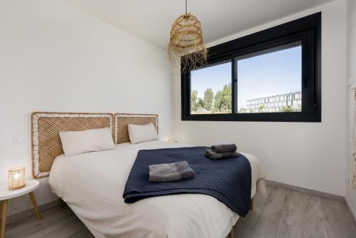 a bedroom with a large white bed with a window at Golden View 2460 in Manilva