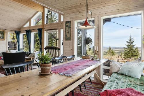 a living room with a wooden table and a large window at Family Cabin With Views Over Hadeland in Roa