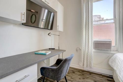 a room with a desk with a chair and a window at Chez Mont Royal Apartments! in Montréal