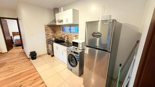 a kitchen with a refrigerator and a washer and dryer at Casa excelente ubicación en Atlántida Sur in Atlántida