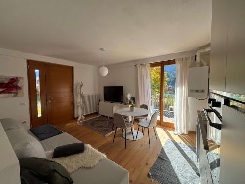 a living room with a bed and a table with chairs at Siera View Apartment - Comfort e Relax a Sappada in Ecche