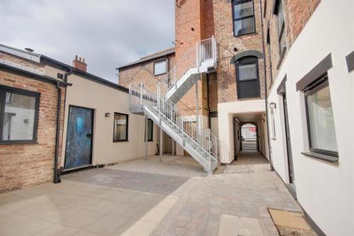 an empty alleyway between two brick buildings with a staircase at The Old Bakehouse, central historical Beverley in Beverley