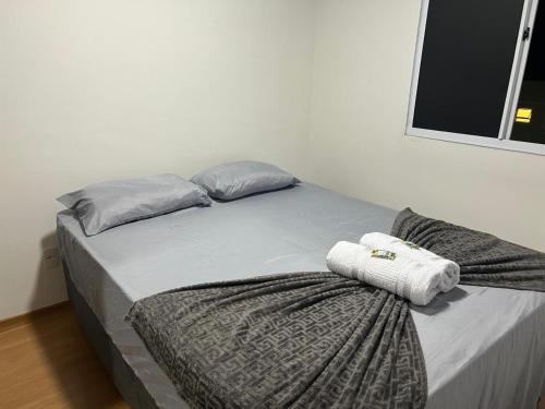 a bed in a room with two pillows on it at Apartamento na Região do Grande Dirceu in Teresina