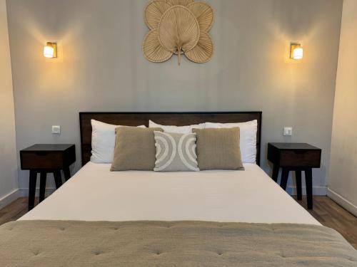ein Schlafzimmer mit einem großen Bett mit zwei Nachttischen in der Unterkunft Koho SXM - ex Hevea Hotel in Grand Case