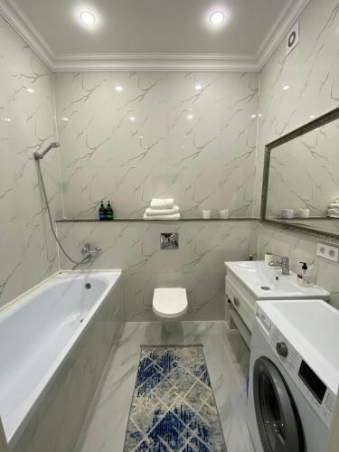 ein Badezimmer mit Badewanne, Toilette und Waschbecken in der Unterkunft Уютная квартира на центре города, возле EXPO in Astana