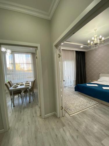 ein Schlafzimmer mit Bett und ein Esszimmer in der Unterkunft Уютная квартира на центре города, возле EXPO in Astana