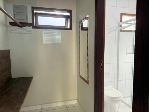a bathroom with a toilet and a window at Pousada Morada da Praia - Ubatuba -Praia Grande in Ubatuba