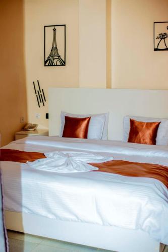 ein Schlafzimmer mit einem großen weißen Bett und dem Eiffelturm in der Unterkunft La Briella Hotel in Gisenyi