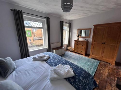 a bedroom with a bed with two towels on it at 3 Bed House-Sleeps 5-Free Parking & Wi-Fi in Sketty