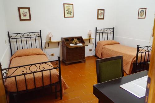 een kamer met 2 bedden, een bureau en een tafel bij Villetta Casa Fiori - I GERANEI in San Savino