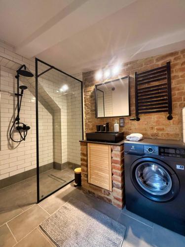 a bathroom with a washing machine and a shower at Siesta by Rentoom in Toruń