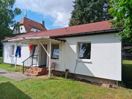 a small white house with a red roof at Möblierte Zimmer mit Gemeinschaftsküchen und Wohnungen in Thüringen Wald in Ohrdruf