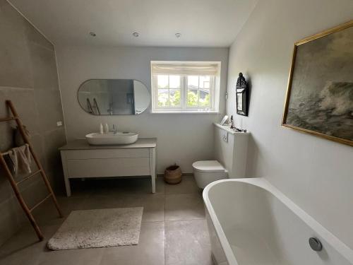 a bathroom with a tub and a toilet and a sink at Summerhouse Denmark in Tisvildeleje 700 m walk from beach in Tisvilde