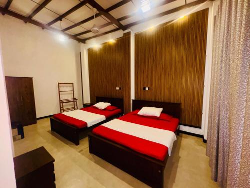 a bedroom with two beds with red and white sheets at Shehan Villa in Beruwala