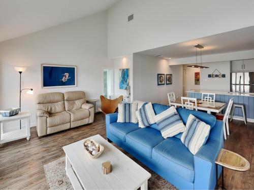 a living room with a blue couch and a table at Sunset Water View in Padre Island
