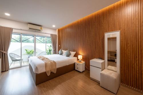 a bedroom with a large bed and a large window at VivaDeva , Pool Villa In Nimman 4BR Near MAYA MALL in Chiang Mai