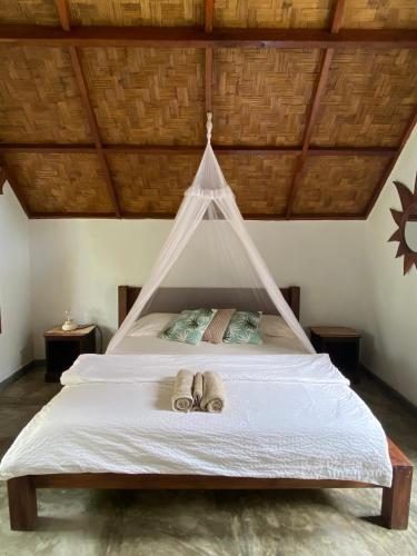 a bedroom with a bed with two slippers on it at Villa Paradise - Bukit Lawang in Bukit Lawang