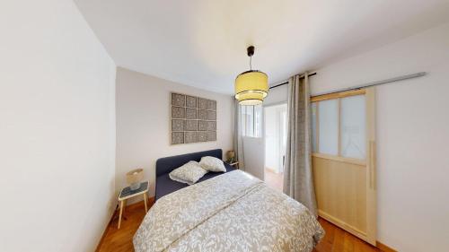 a bedroom with a bed and a pendant light at Maison Magnifique Ernest Renan in Le Havre