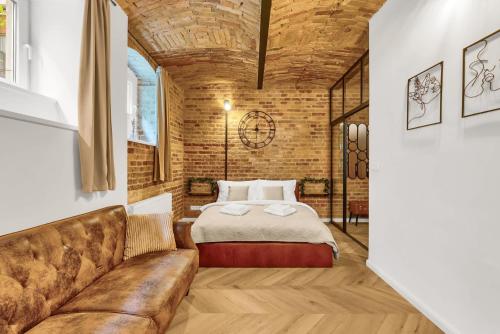 a bedroom with a bed and a couch at The Magnificent Urban Hideaway in Vinohrady