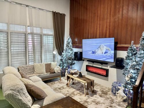 a living room with a tv and christmas trees at Unica Hija Hometel by TahZora in Valencia