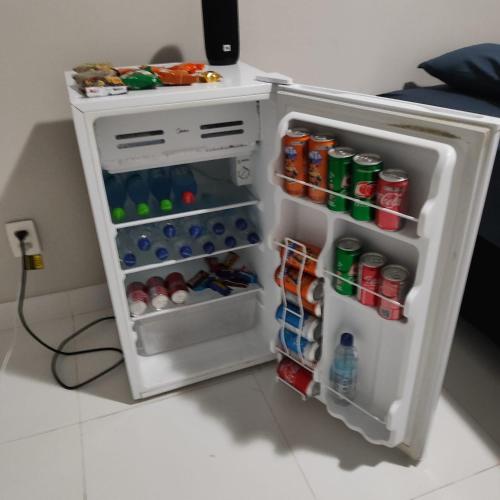 a small refrigerator filled with drinks and soda at Refúgio Urbano in Ji-Paraná