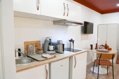 una cucina con un lavello e un piano di lavoro di L'Écrin Rouge Escapade Romantique et Balnéo Privé a Bordeaux
