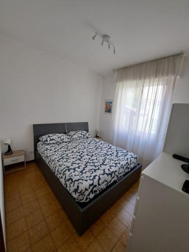 Un dormitorio con una cama con un edredón blanco y negro. en UscioNatura, en Uscio