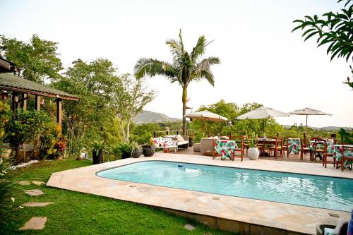 a swimming pool in the yard of a house at Chalé Oxossi in Maricá