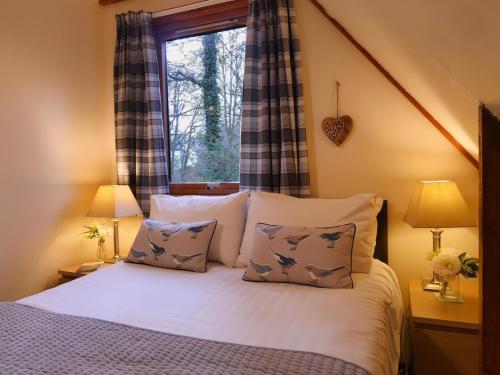 a bedroom with a bed with pillows and a window at Ericht Holiday Lodges in Blairgowrie