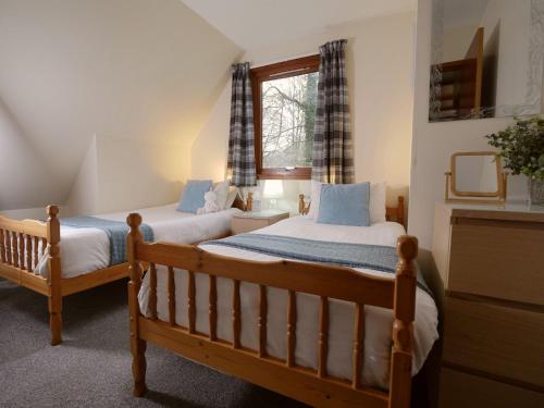 ein Schlafzimmer mit zwei Betten und einem Fenster in der Unterkunft Ericht Holiday Lodges in Blairgowrie