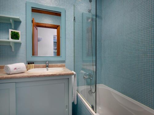 a bathroom with a sink and a shower and a mirror at Akisol Olhos de Água Ocean in Albufeira