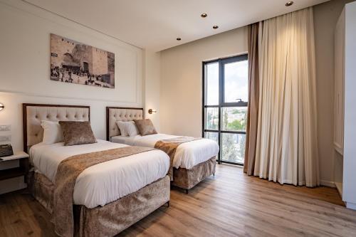 エルサレムにあるLevant Hotelの窓のある部屋にベッドが2つある