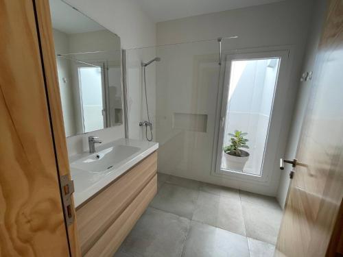 a bathroom with a sink and a shower and a mirror at Caleta de Famara Casa acogedora y espaciosa in Famara