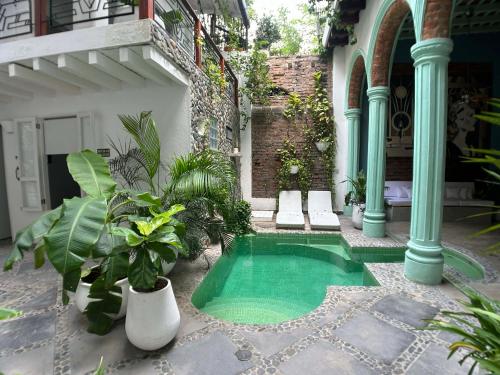 a small swimming pool in a courtyard with plants at Casa Verde Hotel in Santa Marta
