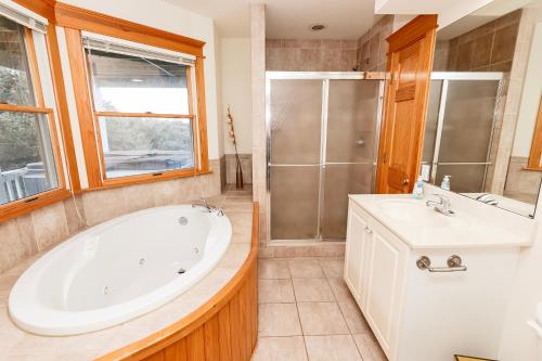 a bathroom with a tub and a sink and a shower at SEMI-OCEANFRONT, Wild Horses, Private Pool-4x2238, Finally Here in Knotts Island
