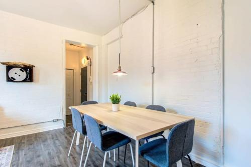 a dining room with a wooden table and blue chairs at Chez Mont Royal Apartments! in Montréal