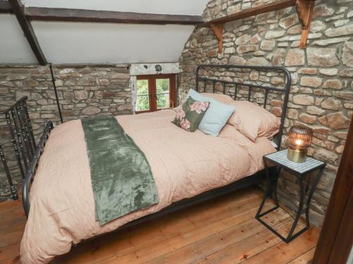 a bedroom with a bed in a stone wall at Arian in Aber-nant