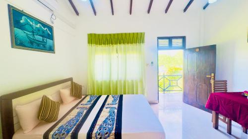 une chambre avec un lit, une fenêtre et une table dans l'établissement New Peacock Resort, à Dambulla