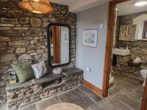 a stone bathroom with a sink and a mirror at Gwyn Studio in Aber-nant