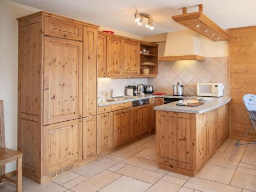 a kitchen with wooden cabinets and a counter top at Apartment Ardève 7 by Interhome in Ovronnaz