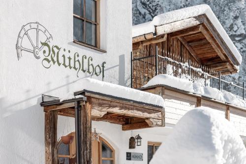 a building covered in snow with a balcony at MYALPS Mühlhof inklusive Sauna in Oetz