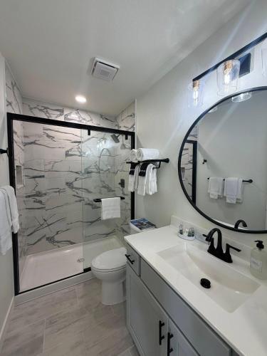 a bathroom with a shower and a toilet and a sink at Sunset Beach Resort in Osage Beach