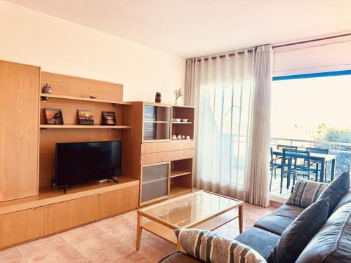 a living room with a couch and a television at Apartment Port Pals Golden by Interhome in Pals