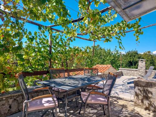 une table et des chaises sur une terrasse sous une pergola dans l'établissement Holiday Home Ljudevit by Interhome, à Dobrinj